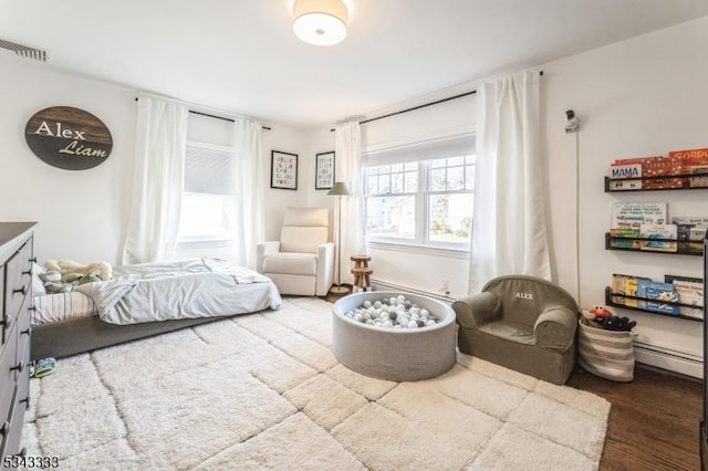 bedroom featuring visible vents and wood finished floors