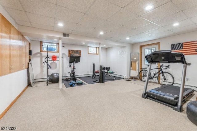 exercise area featuring visible vents, a drop ceiling, a baseboard heating unit, recessed lighting, and baseboards