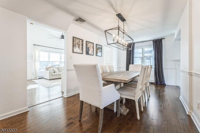 dining room with ceiling fan with notable chandelier, dark wood-style floors, visible vents, and a wealth of natural light