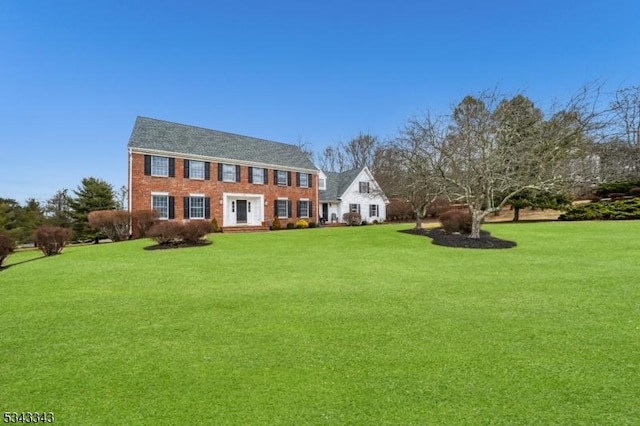 view of front facade featuring brick siding and a front lawn