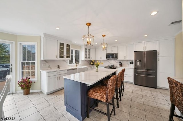 kitchen featuring light tile patterned floors, white cabinetry, stainless steel appliances, and a sink