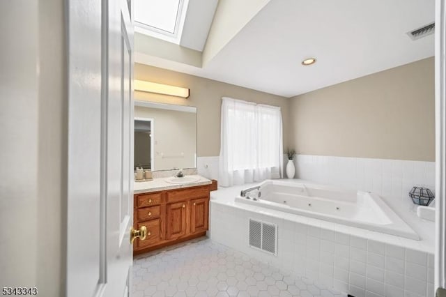 full bathroom with vanity, visible vents, a skylight, tile patterned flooring, and a jetted tub