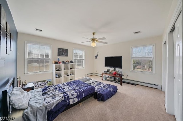 carpeted bedroom with multiple windows, visible vents, and baseboard heating