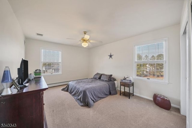 carpeted bedroom featuring visible vents, a ceiling fan, a baseboard heating unit, and baseboards