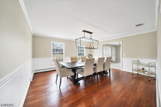 dining room featuring visible vents, ornamental molding, baseboards, baseboard heating, and dark wood-style flooring