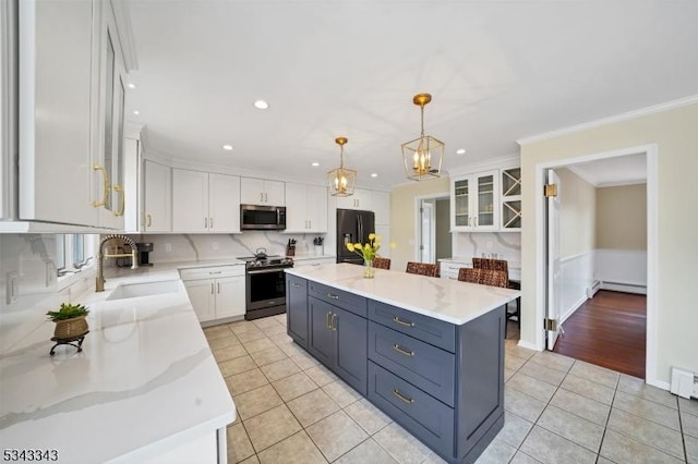 kitchen with light tile patterned floors, baseboard heating, white cabinets, stainless steel appliances, and a sink