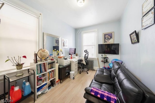 home office with radiator heating unit and wood finished floors