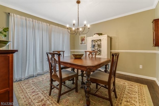 dining room with an inviting chandelier, wood finished floors, baseboards, and ornamental molding