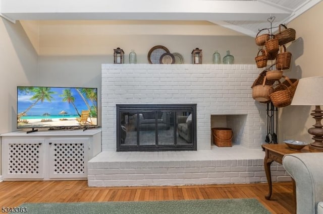 room details featuring a brick fireplace and wood finished floors