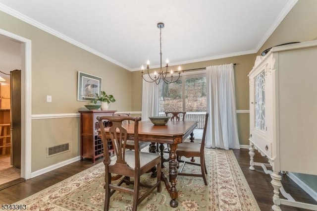 dining space with crown molding, wood finished floors, and a chandelier