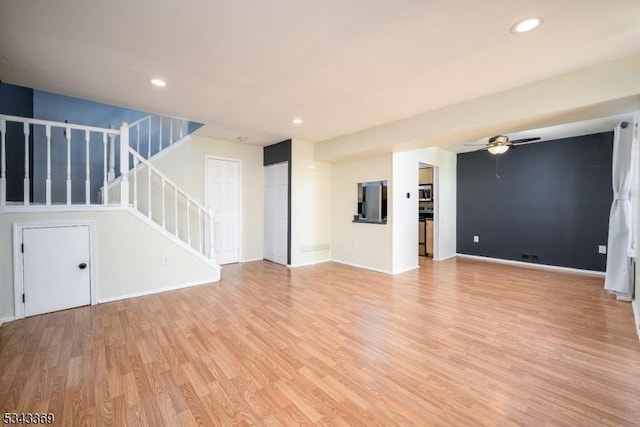 unfurnished living room featuring recessed lighting, a ceiling fan, light wood-style floors, and stairs