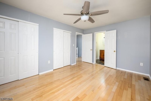 unfurnished bedroom featuring visible vents, baseboards, two closets, and light wood-style flooring