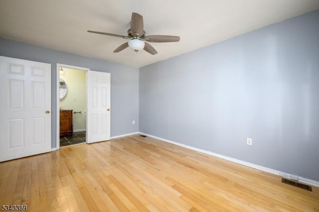 unfurnished bedroom featuring a ceiling fan, baseboards, visible vents, ensuite bath, and light wood-type flooring