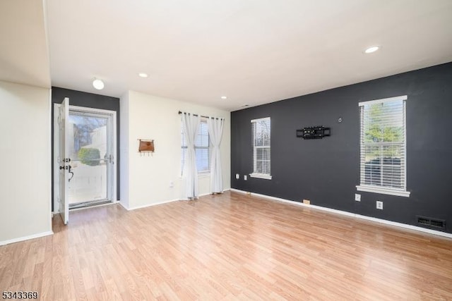 spare room with light wood finished floors, visible vents, recessed lighting, and baseboards