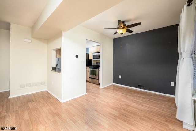 unfurnished room featuring visible vents, light wood-style floors, baseboards, and ceiling fan