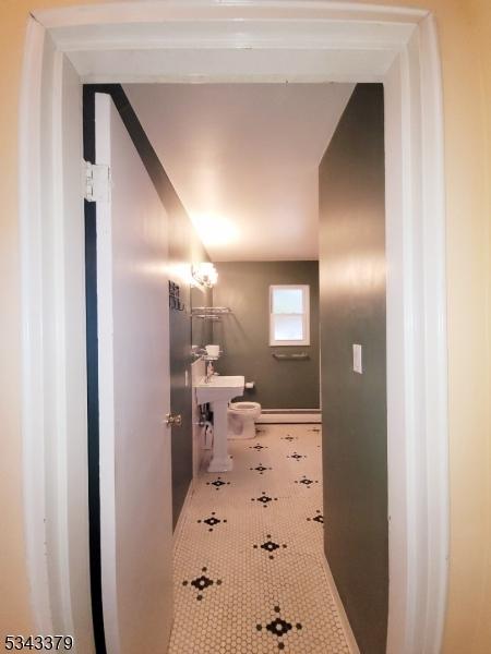 half bath with toilet and tile patterned flooring