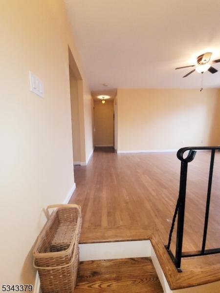 hall featuring wood finished floors and baseboards