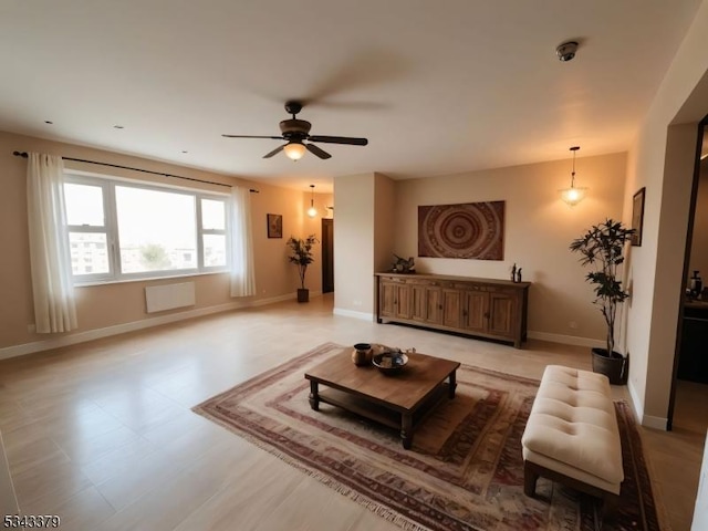 living room featuring a ceiling fan and baseboards