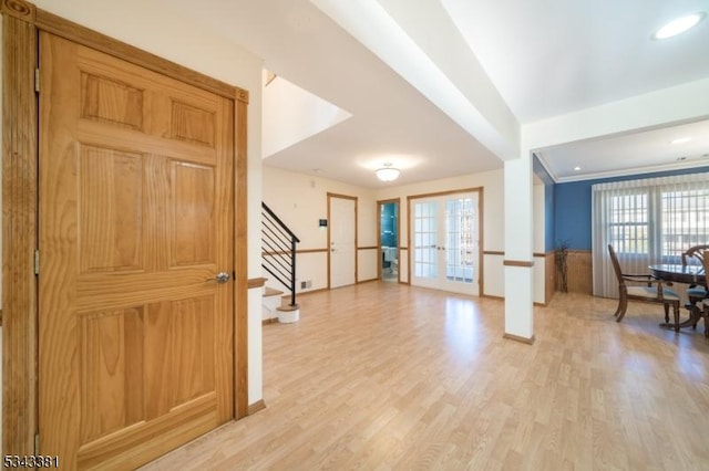 entrance foyer with stairs, light wood-style flooring, french doors, and baseboards