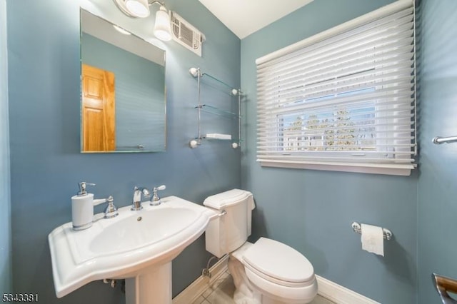 bathroom with visible vents, toilet, baseboards, and a sink