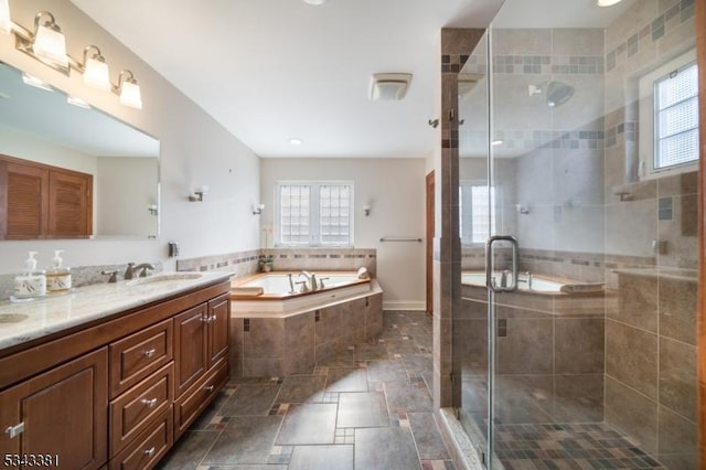 bathroom with double vanity, a bath, a shower stall, and a sink