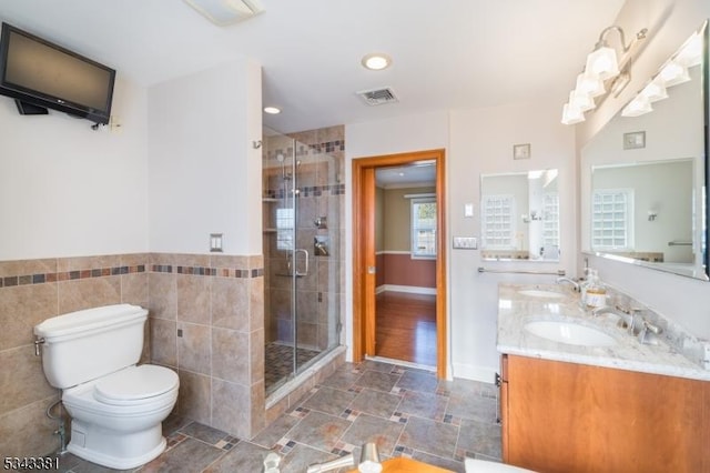 full bath with a sink, visible vents, toilet, and a stall shower