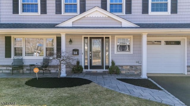 doorway to property with a porch and roof with shingles