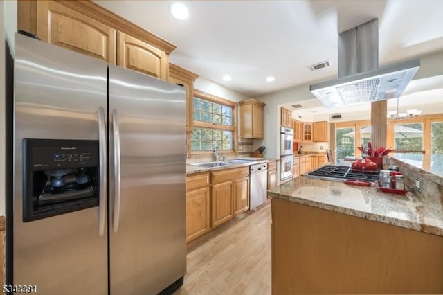 kitchen featuring visible vents, a wealth of natural light, appliances with stainless steel finishes, island exhaust hood, and a sink