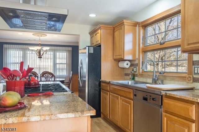 kitchen featuring an inviting chandelier, a sink, light wood-style floors, appliances with stainless steel finishes, and backsplash