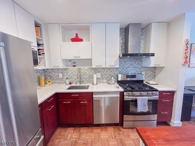 kitchen featuring open shelves, a sink, appliances with stainless steel finishes, wall chimney range hood, and backsplash