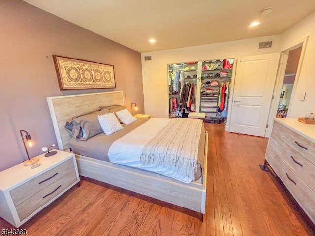 bedroom featuring visible vents, recessed lighting, wood finished floors, and a closet