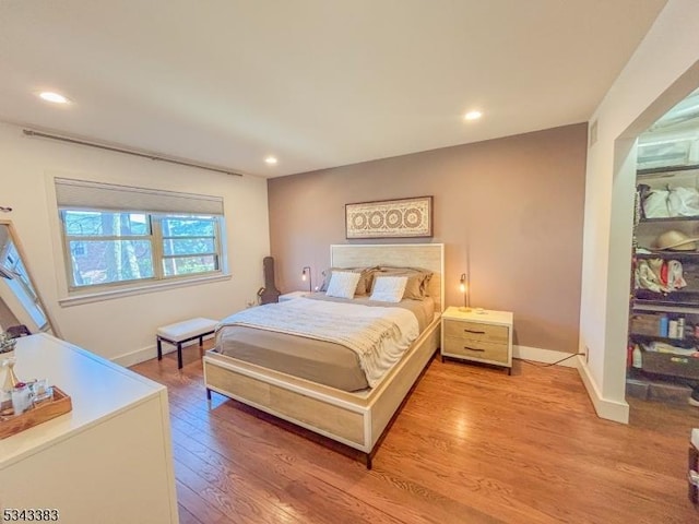 bedroom with recessed lighting, light wood-style floors, and baseboards