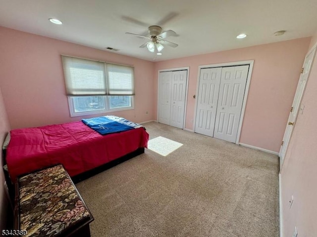 carpeted bedroom with visible vents, recessed lighting, baseboards, and multiple closets