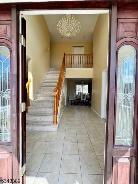 entrance foyer featuring stairs, a high ceiling, and light tile patterned floors