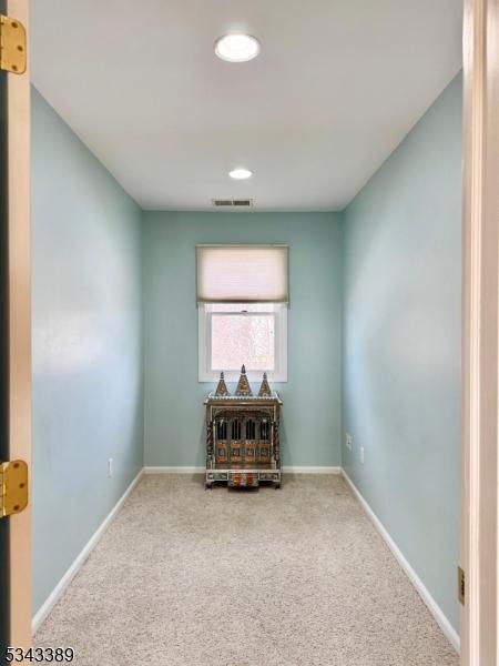 carpeted empty room with visible vents and baseboards