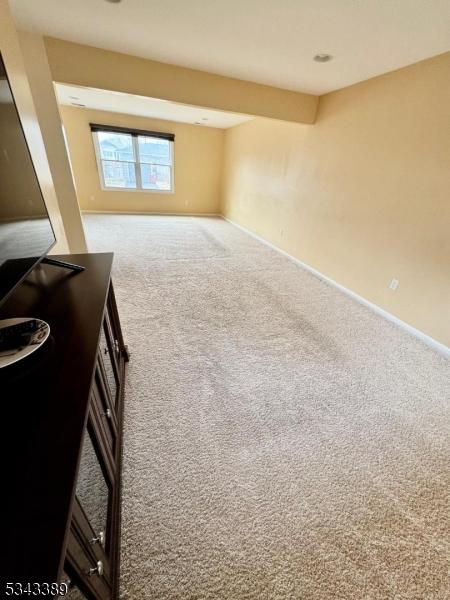 living area featuring carpet and baseboards