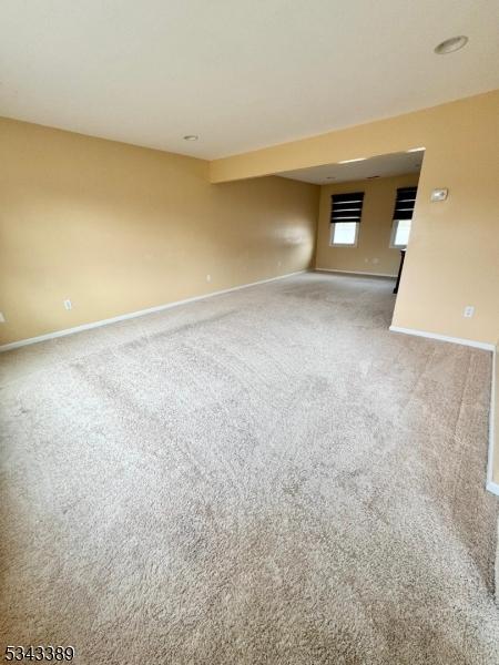 carpeted empty room with baseboards