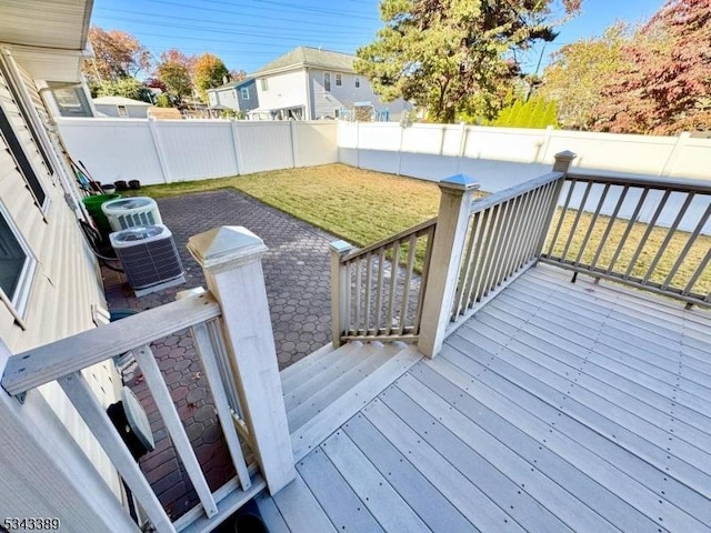 deck with central AC unit, a yard, and a fenced backyard