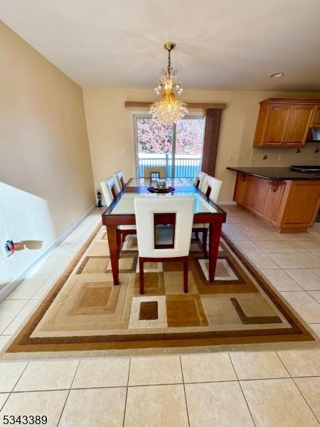 dining room with an inviting chandelier and light tile patterned floors