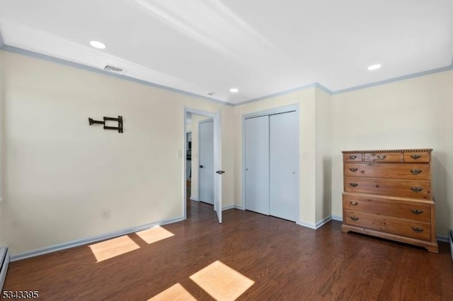 unfurnished bedroom featuring visible vents, crown molding, recessed lighting, wood finished floors, and a closet