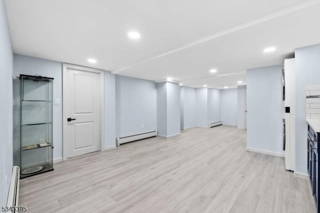 finished basement with recessed lighting, a baseboard heating unit, baseboard heating, and light wood-style flooring