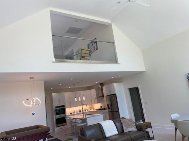 living area with recessed lighting, baseboards, and high vaulted ceiling