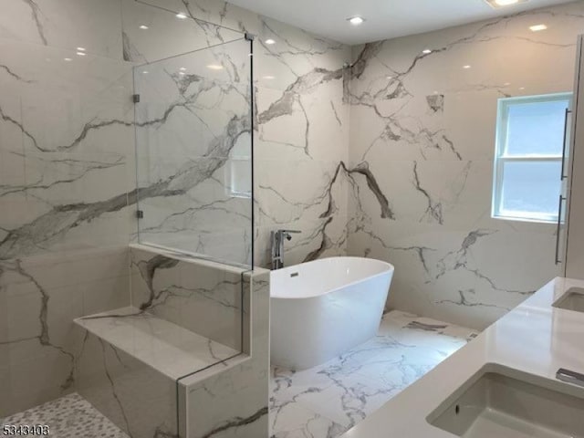 full bathroom with stone wall, a marble finish shower, and a freestanding bath