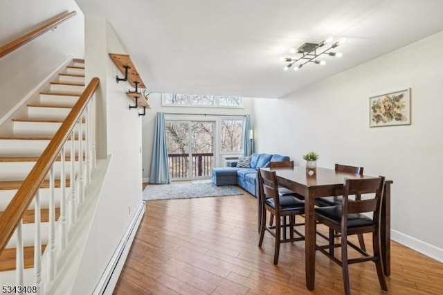 dining room with baseboards, wood finished floors, and stairs