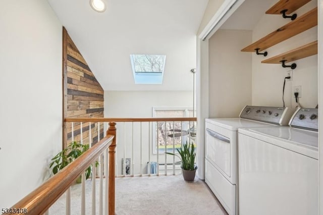 washroom with washer and clothes dryer, laundry area, light colored carpet, and a skylight