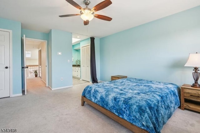 carpeted bedroom with ceiling fan, attic access, connected bathroom, and baseboards