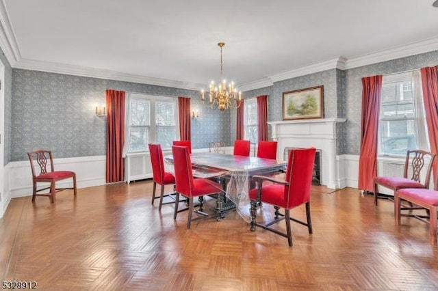 dining space with plenty of natural light, a notable chandelier, wainscoting, and wallpapered walls