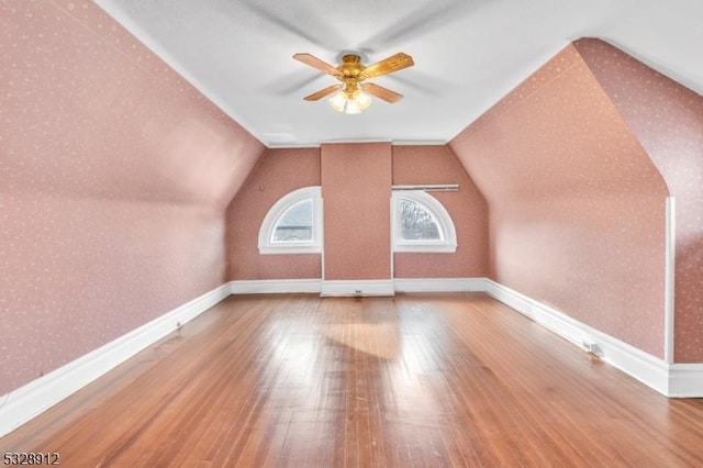 bonus room featuring wallpapered walls, lofted ceiling, and wood-type flooring