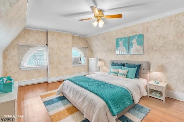 bedroom featuring wallpapered walls, crown molding, baseboards, vaulted ceiling, and wood finished floors