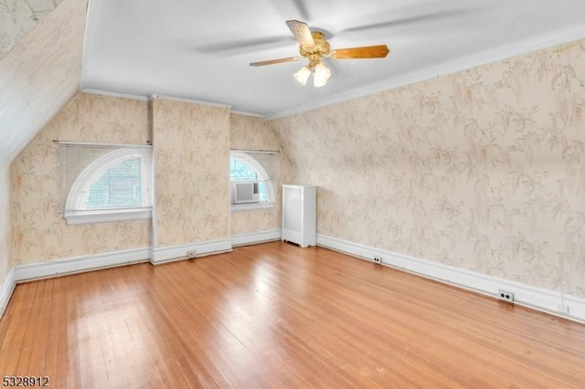 bonus room with vaulted ceiling, wallpapered walls, baseboards, and hardwood / wood-style floors